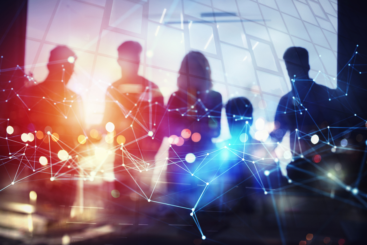 Silhouettes of a team behind a glowing network of connected nodes.